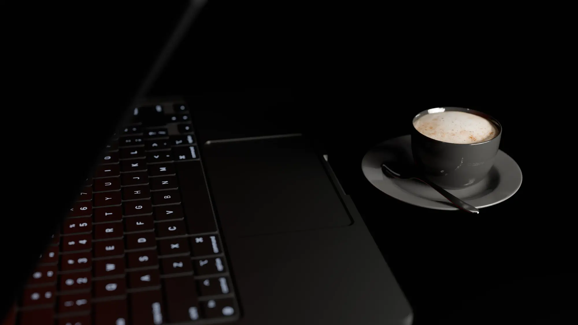 Laptop keyboard and a cup of coffee in low light